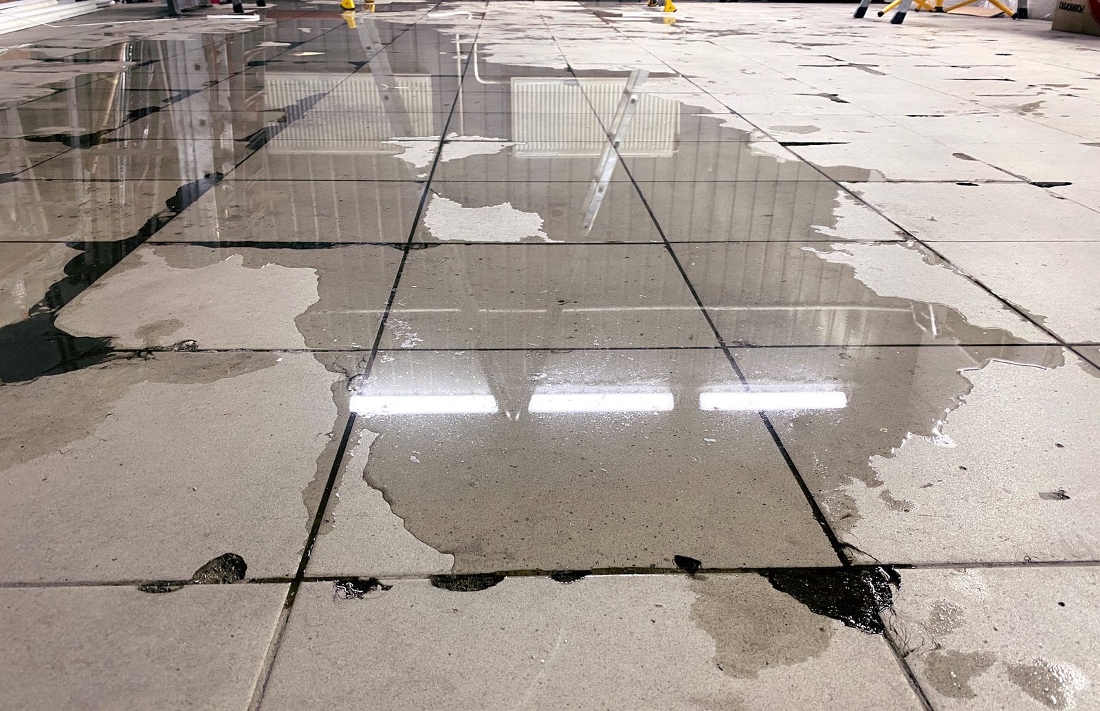 Puddled water covering a tiled floor after a flood